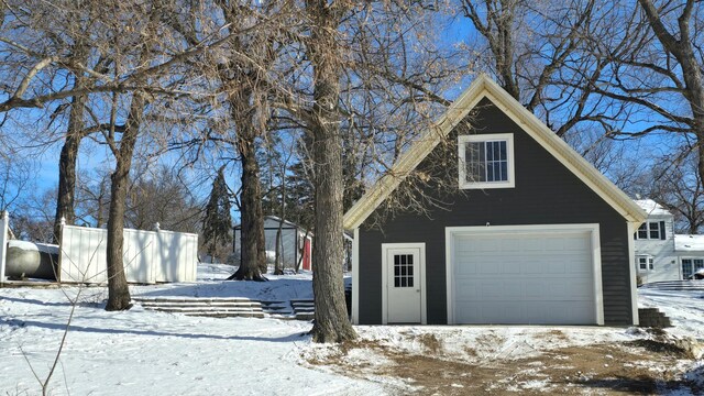 snow covered garage featuring a garage