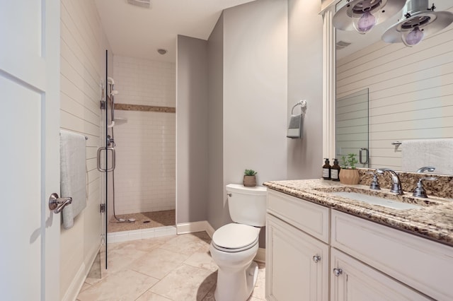 full bath featuring vanity, a shower stall, toilet, and baseboards