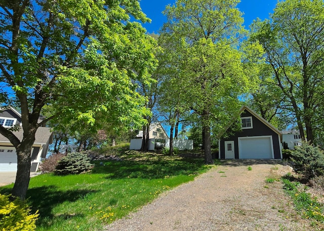 7 County Road 12 S, Buffalo, MN 55313 - obstructed view of property featuring dirt driveway, an outbuilding, a detached garage, and a front lawn