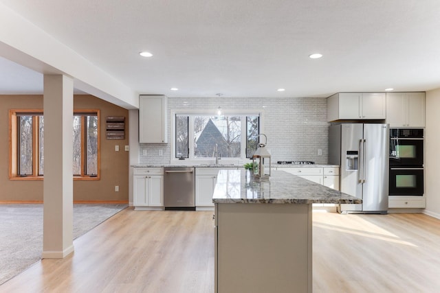 3571 Centerville Rd, Vadnais Heights, MN 55127 - kitchen featuring stainless steel appliances, decorative backsplash, a kitchen island, light wood-style floors, and recessed lighting