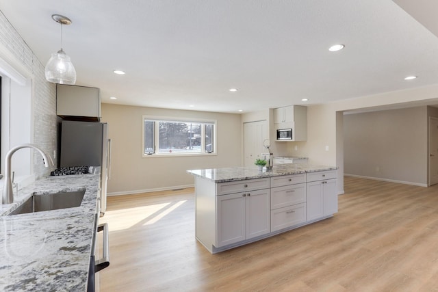 3571 Centerville Rd, Vadnais Heights, MN 55127 - kitchen featuring stainless steel appliances, a sink, baseboards, light wood-style flooring, and decorative light fixtures