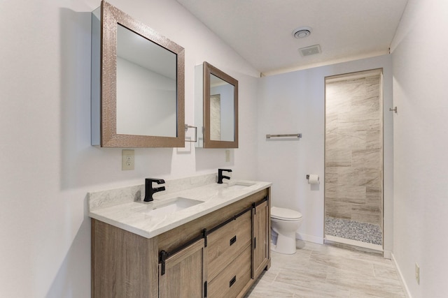 3571 Centerville Rd, Vadnais Heights, MN 55127 - bathroom featuring toilet, double vanity, a tile shower, marble finish flooring, and baseboards