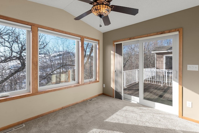 interior space with ceiling fan, lofted ceiling, and light carpet