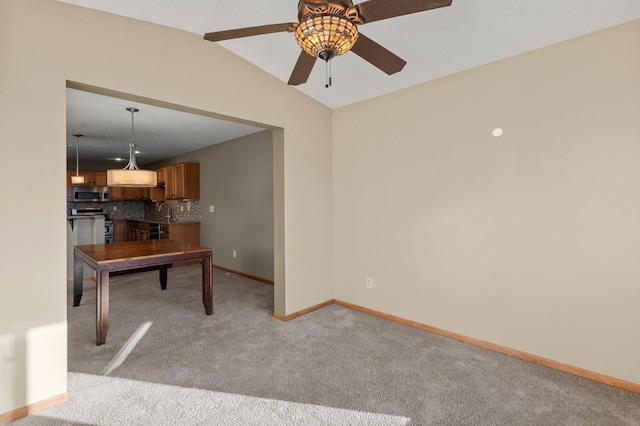 interior space featuring vaulted ceiling, light colored carpet, and ceiling fan