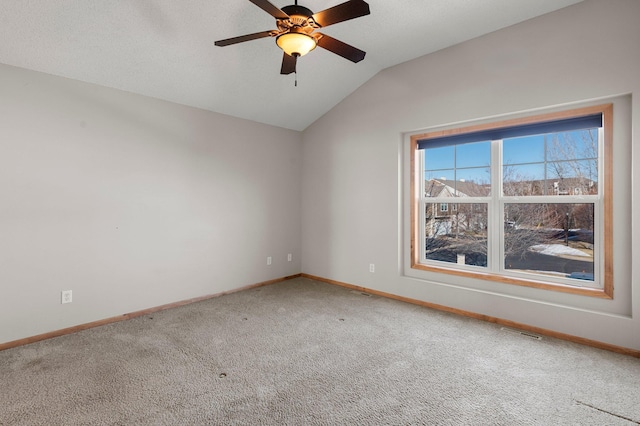 spare room with carpet floors, vaulted ceiling, and ceiling fan