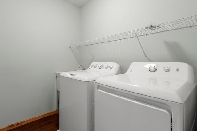 clothes washing area featuring dark hardwood / wood-style floors and separate washer and dryer