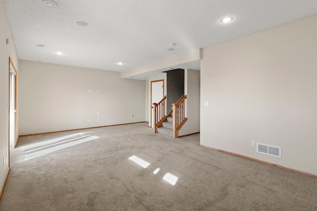 carpeted spare room with a textured ceiling