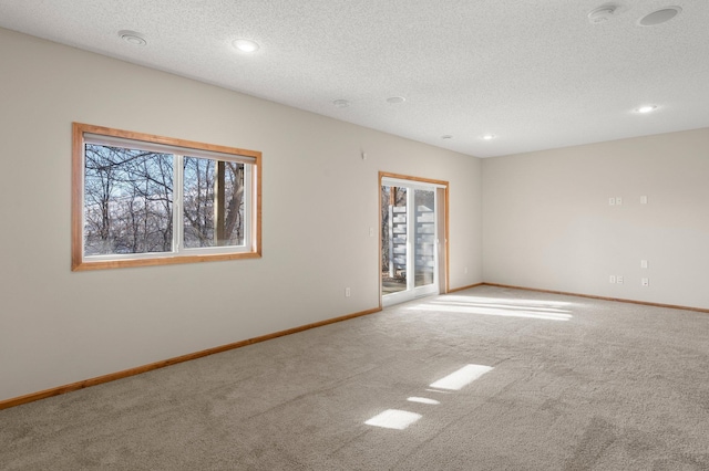 carpeted empty room featuring a textured ceiling