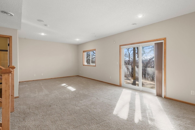 carpeted spare room featuring a textured ceiling