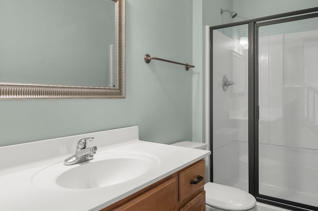 bathroom with walk in shower, vanity, and toilet