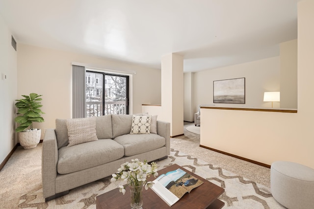 living area with light carpet, visible vents, and baseboards