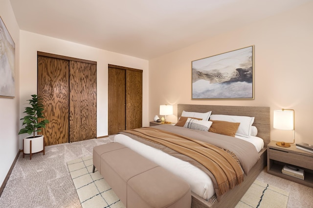 bedroom featuring light carpet and two closets