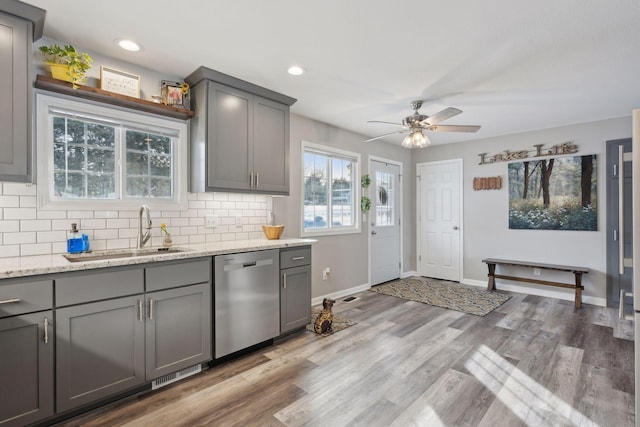 kitchen featuring gray cabinets, hardwood / wood-style flooring, sink, and stainless steel dishwasher