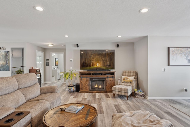 living room with light hardwood / wood-style floors and a textured ceiling