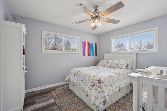 bedroom featuring dark wood-type flooring, ceiling fan, and multiple windows