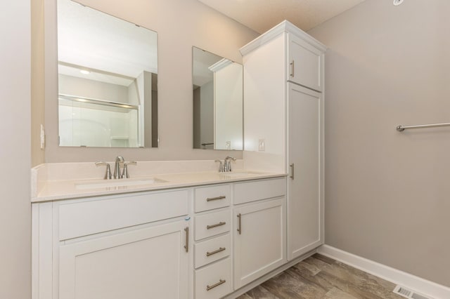 bathroom featuring vanity, hardwood / wood-style floors, and a shower with shower door