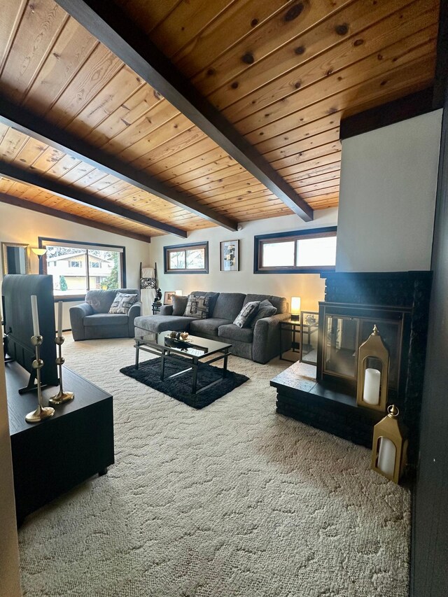 living room featuring a healthy amount of sunlight, carpet flooring, beam ceiling, and wooden ceiling