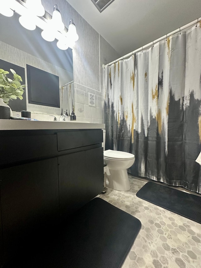 bathroom with vanity, tile walls, a chandelier, and toilet