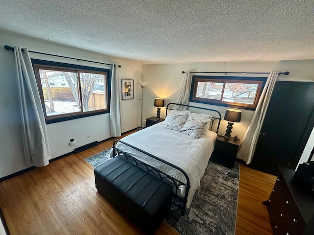 bedroom with light hardwood / wood-style floors and a textured ceiling