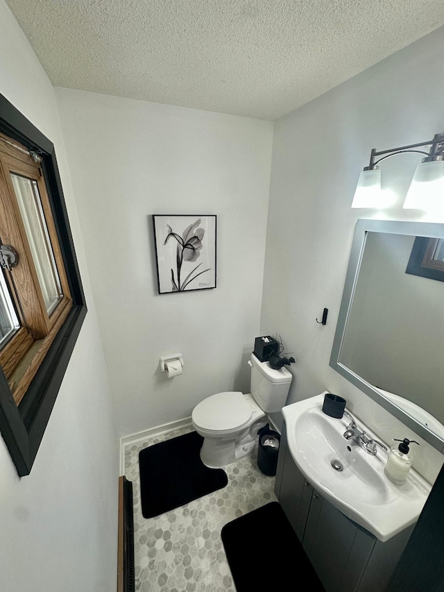 bathroom featuring vanity, a textured ceiling, and toilet