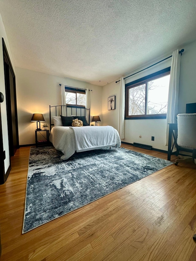 bedroom with hardwood / wood-style flooring and a textured ceiling