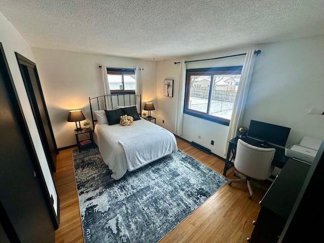 bedroom with light hardwood / wood-style flooring and a textured ceiling