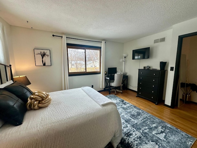 bedroom with hardwood / wood-style flooring and a textured ceiling