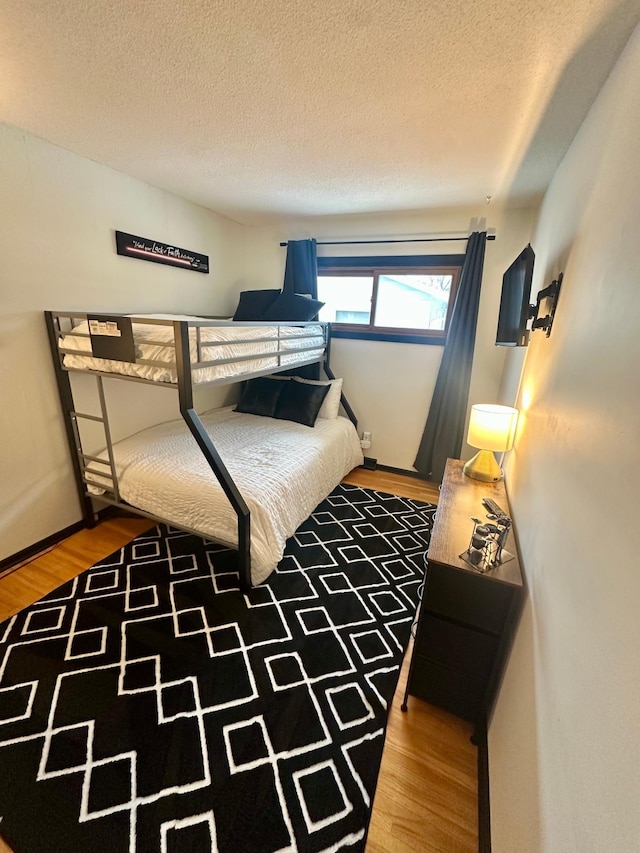 bedroom with wood-type flooring and a textured ceiling