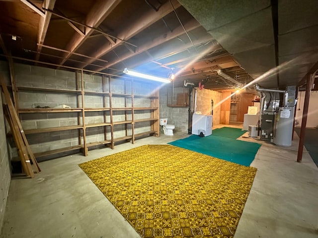 basement with heating unit and washing machine and clothes dryer