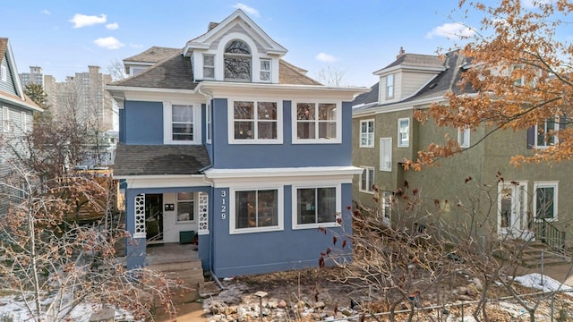 view of front of home with stucco siding and roof with shingles