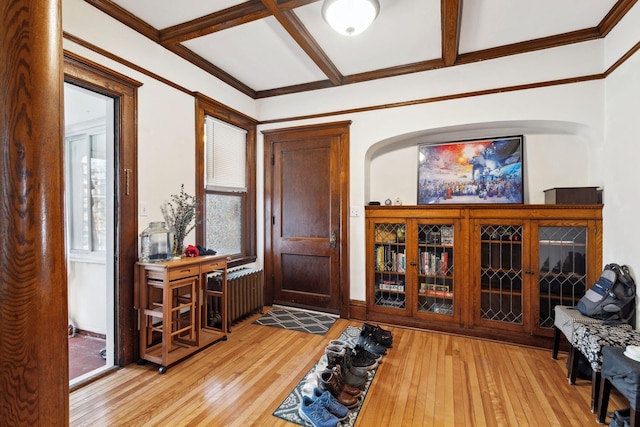 foyer entrance featuring light wood-type flooring, beam ceiling, coffered ceiling, and crown molding