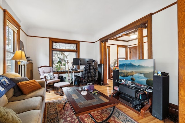 living room with wood finished floors and ornate columns