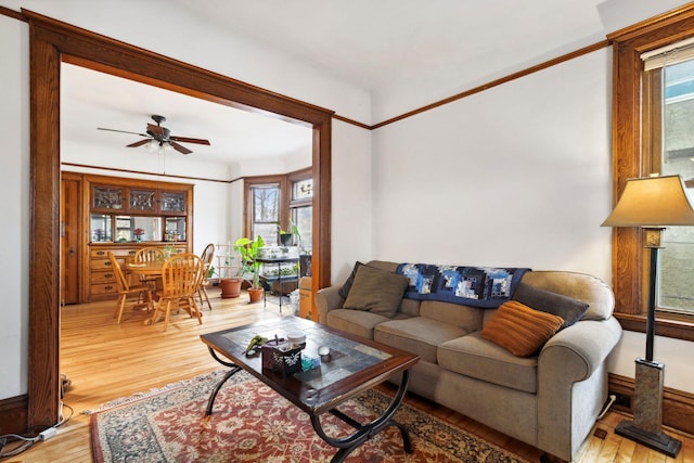 living room with light wood-type flooring and a ceiling fan