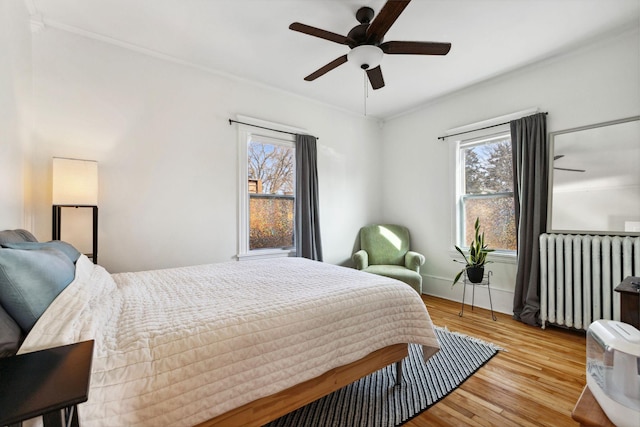 bedroom featuring ceiling fan, wood finished floors, and radiator