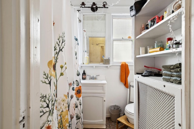 bathroom with toilet, tile patterned flooring, and vanity