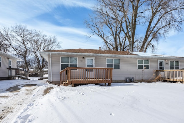 snow covered property featuring a wooden deck