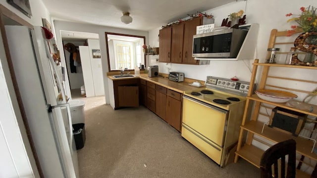 kitchen with white refrigerator, sink, and stove