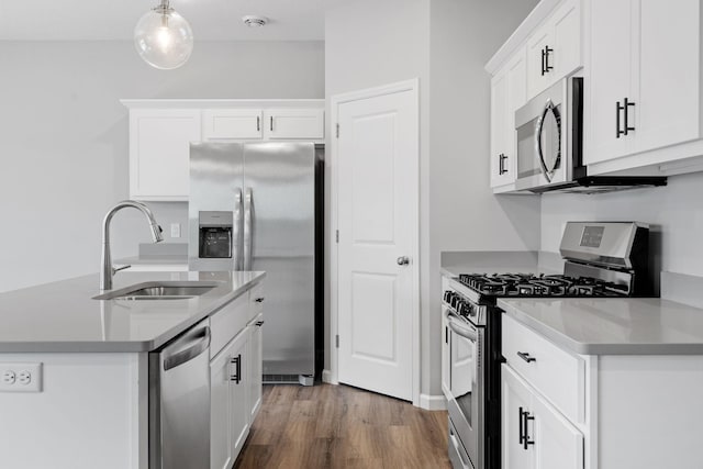 kitchen featuring appliances with stainless steel finishes, dark hardwood / wood-style floors, pendant lighting, white cabinetry, and sink