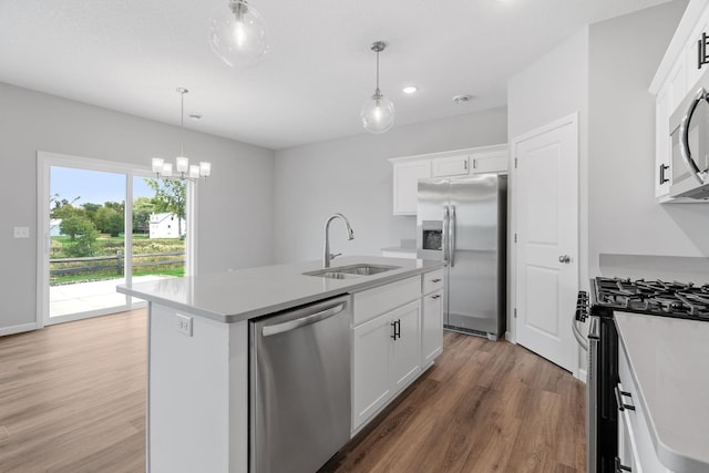 kitchen featuring stainless steel appliances, sink, a center island with sink, and white cabinets