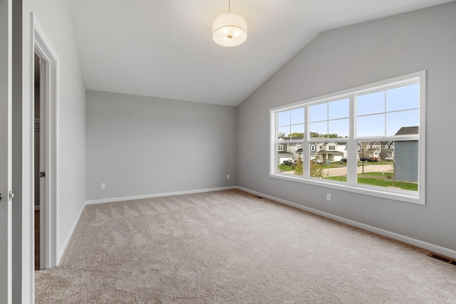 interior space with light colored carpet and vaulted ceiling