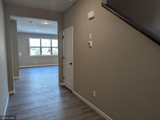 hall with baseboards and wood finished floors