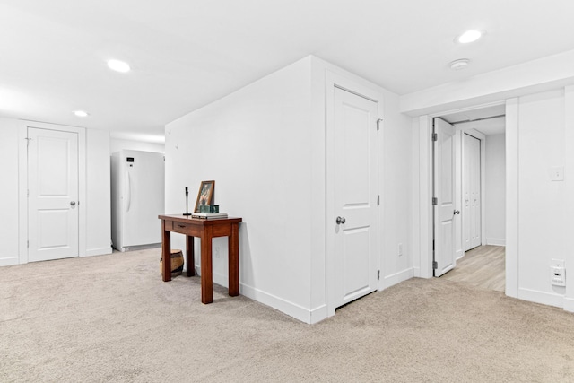 hall featuring recessed lighting, light carpet, and baseboards