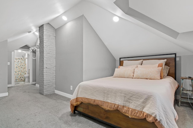 carpeted bedroom with baseboards and vaulted ceiling