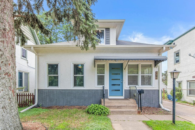 bungalow with brick siding and fence