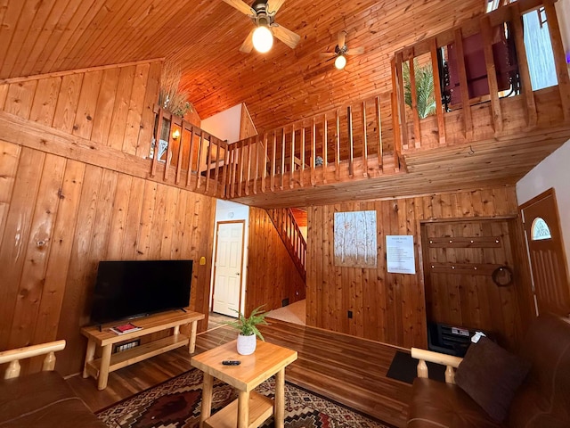 living room featuring wood walls, wood ceiling, wood-type flooring, high vaulted ceiling, and ceiling fan