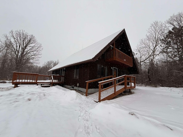 view of snowy exterior featuring a wooden deck