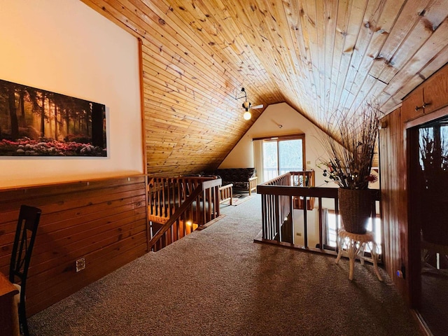 interior space with lofted ceiling, wood ceiling, wooden walls, and carpet flooring