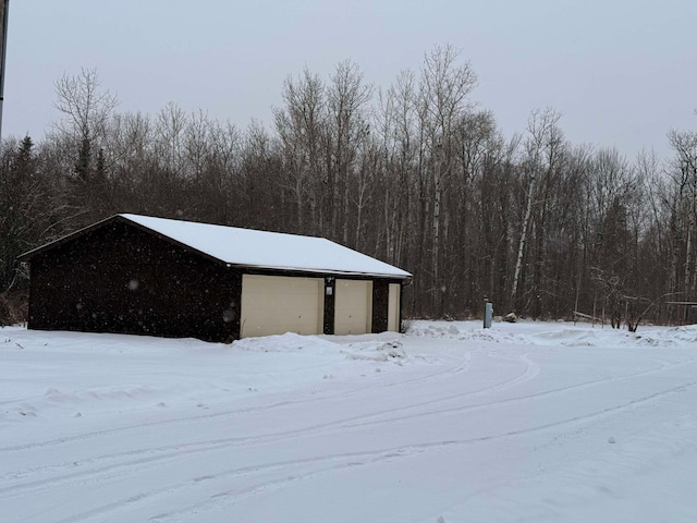 snowy yard with a garage