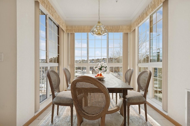 dining room featuring a chandelier, ornamental molding, and baseboards