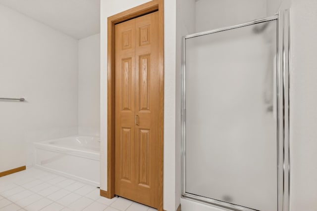 full bath with tile patterned flooring, baseboards, a closet, a bath, and a stall shower